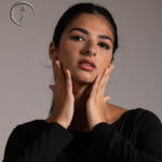 Close-up of a woman with hands on her face.