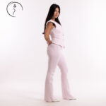 Woman in a light pink vest and pants suit.
