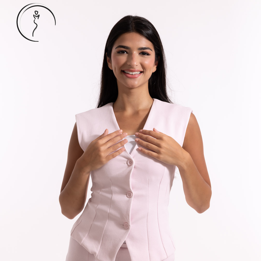 Smiling woman in a light pink vest.