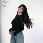 Studio portrait of a woman in casual jeans and fitted black shirt. Female model in Kuwait.