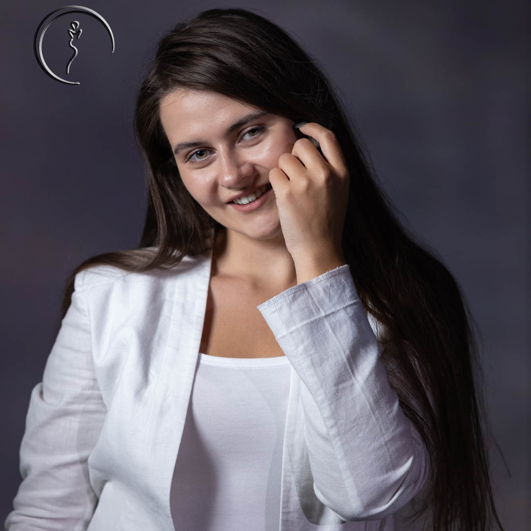 Smiling model in white top and jacket.