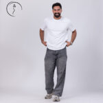 Man in a white t-shirt and loose grey jeans.