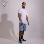 Kuwaiti male model posing in a white t-shirt and denim shorts in a photo studio