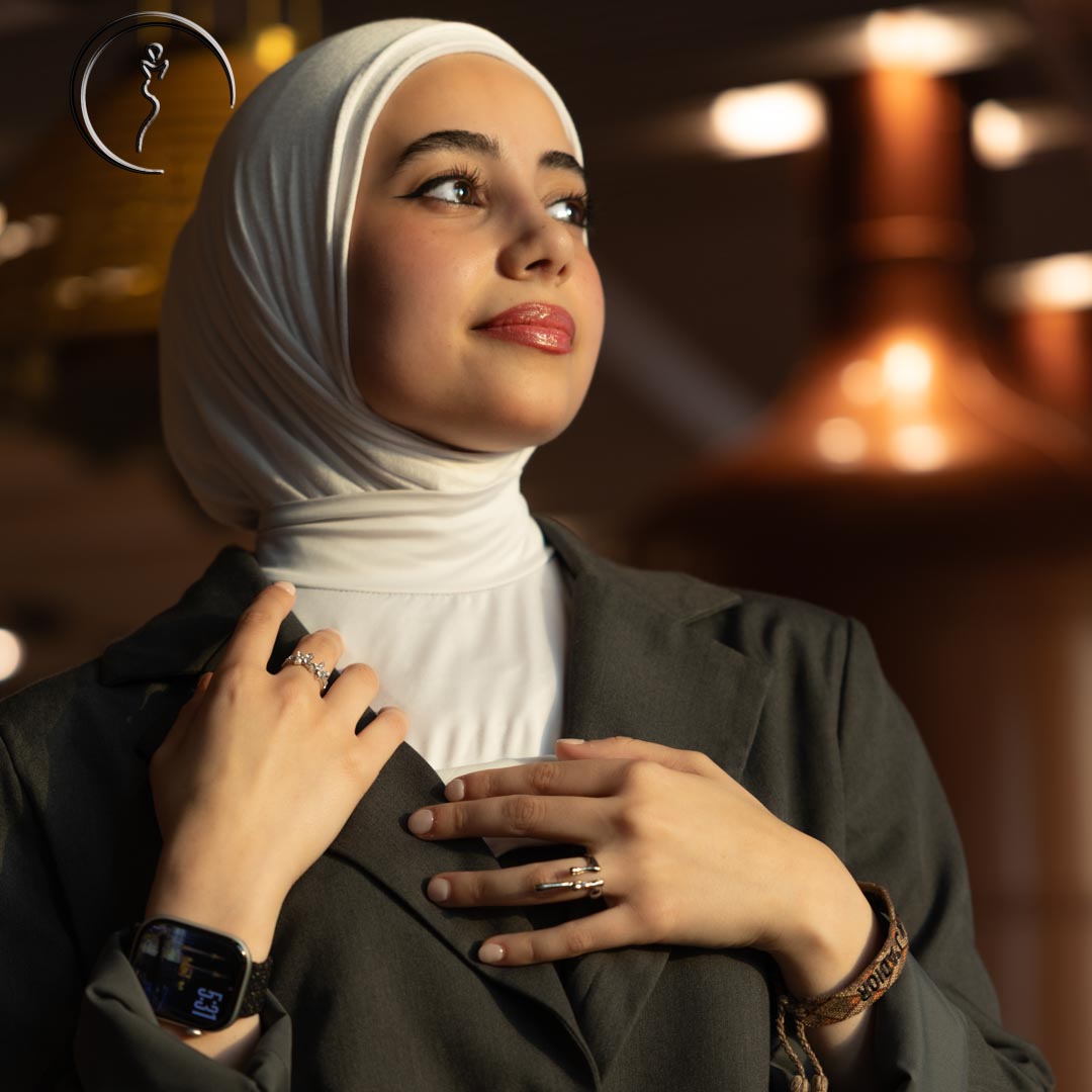 A close-up of a model in a hijab and suit looking up.