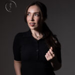 Woman in black polo shirt looking away.