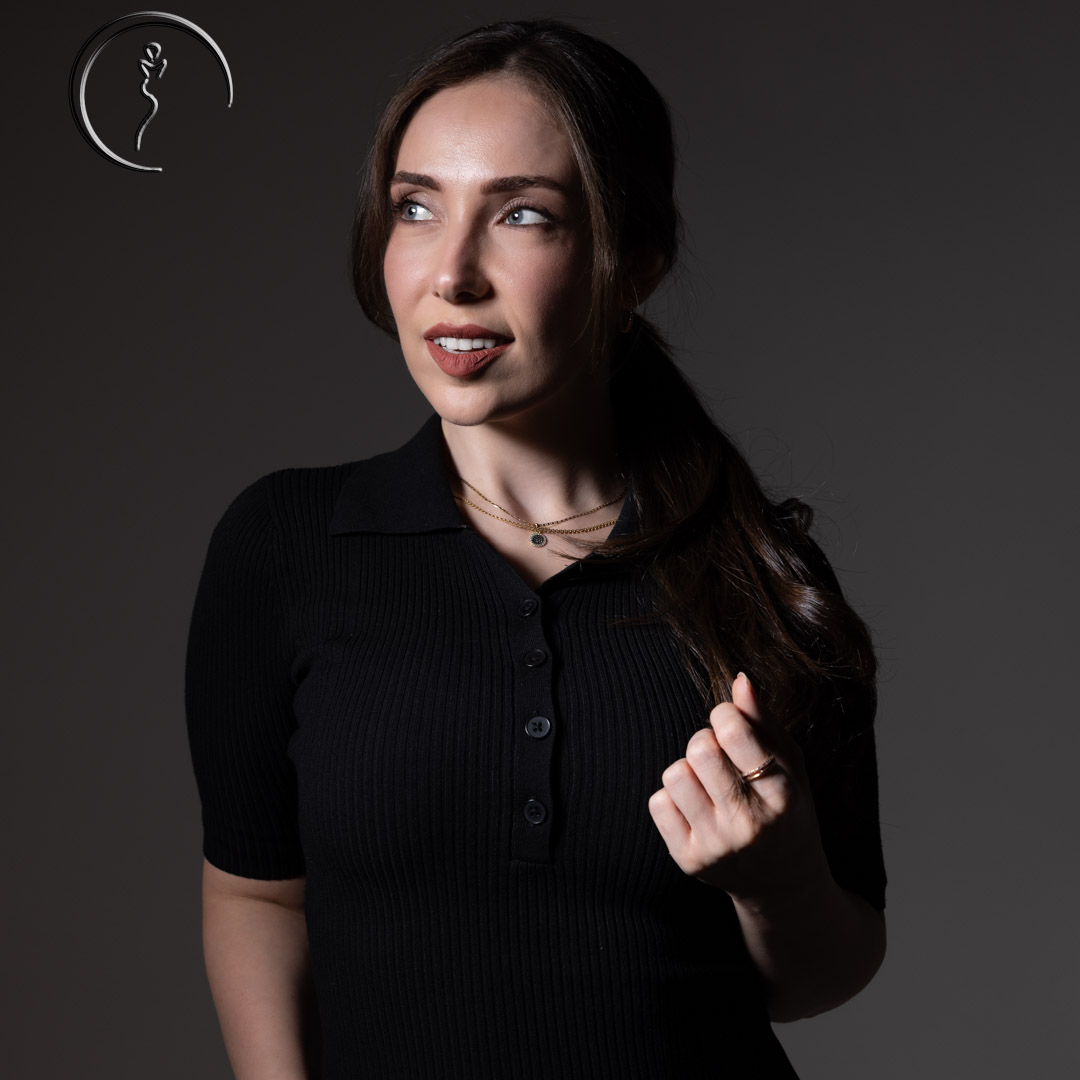 Woman in black polo shirt looking away.