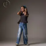 Girl dancing with headphones and a smile.