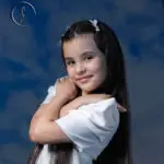 Kid fashion model with long hair in white dress