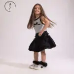 4-year-old Kuwaiti female model posing in stylish black skirt and gray top