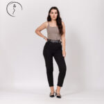 Confident woman standing in taupe top and black trousers
