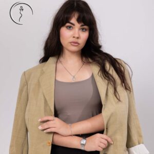 Woman in beige blazer over taupe top posing confidently