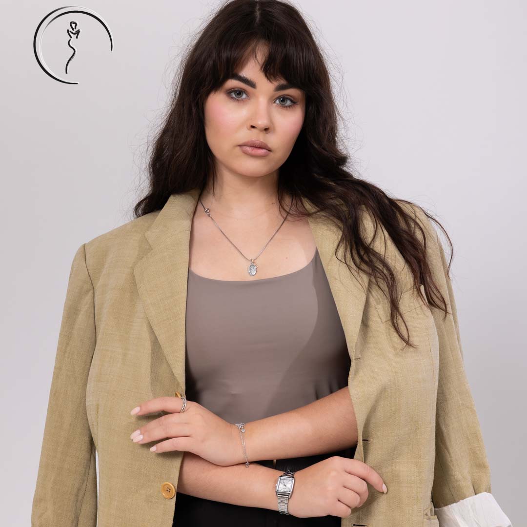 Woman in beige blazer over taupe top posing confidently