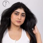 A close-up portrait of an Indian model with her long dark hair flowing around her face