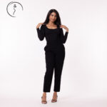A full-body shot of a female model in black pants and a black shirt.