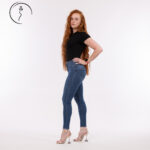 A full-body shot of a red-haired woman in jeans and heels.