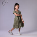 Kid model posing in an olive green floral dress