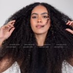 Curly haired female model in Kuwait in black top and blue jeans, full-length portrait – Model 689, Promodel Service