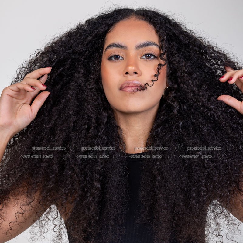 Curly haired female model in Kuwait in black top and blue jeans, full-length portrait – Model 689, Promodel Service