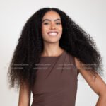 Curly haired model in Kuwait seated on the studio floor in a brown dress – Model 689