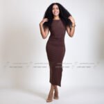 New model in Kuwait with long curly hair in black top and wide-leg jeans, hand in hair – Model 689