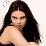 Female model in Kuwait with long dark hair looking over her shoulder, black top, portrait shoot – Model 690